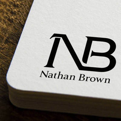 Close-up of a business card featuring the 'NB' monogram and the name 'Nathan Brown' printed in a clean, modern font.